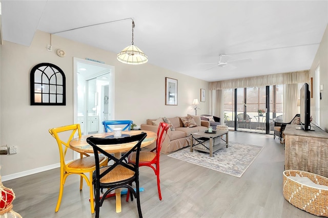 dining room featuring baseboards, wood finished floors, and a ceiling fan