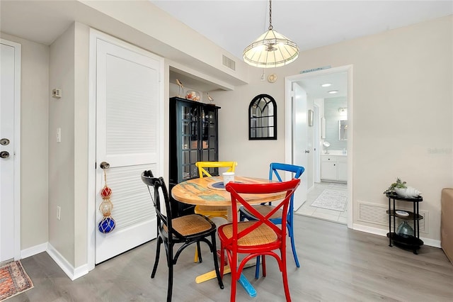 dining room featuring visible vents, baseboards, and wood finished floors