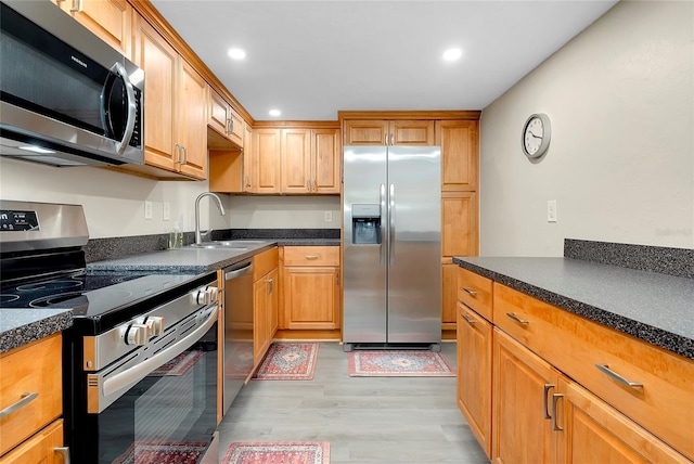 kitchen featuring dark countertops, recessed lighting, stainless steel appliances, and light wood-style floors