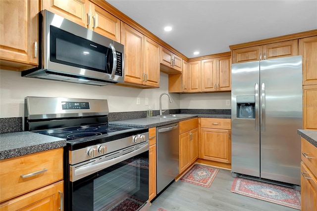 kitchen with a sink, dark countertops, and stainless steel appliances