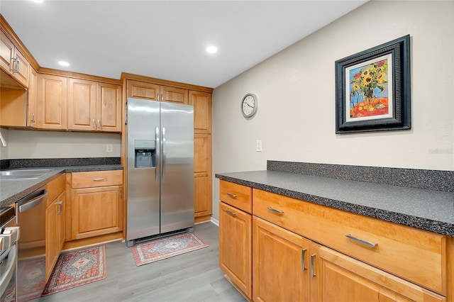 kitchen with dark countertops, recessed lighting, light wood finished floors, and stainless steel appliances