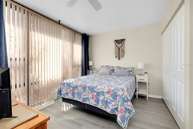 bedroom featuring a closet, a ceiling fan, baseboards, and wood finished floors