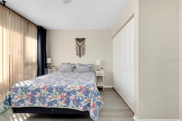 bedroom with a closet, baseboards, and wood finished floors