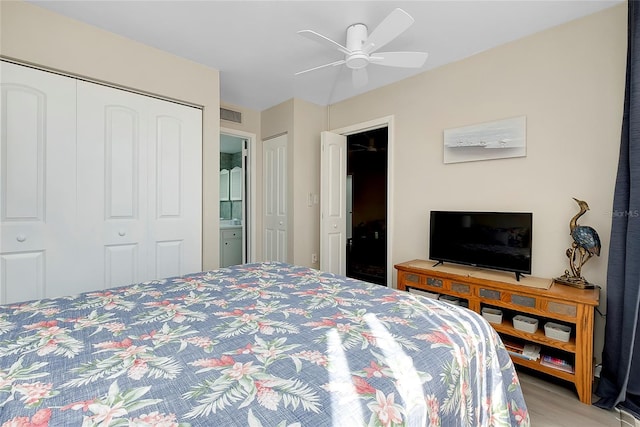 bedroom with visible vents, light wood-style flooring, ensuite bath, and a ceiling fan