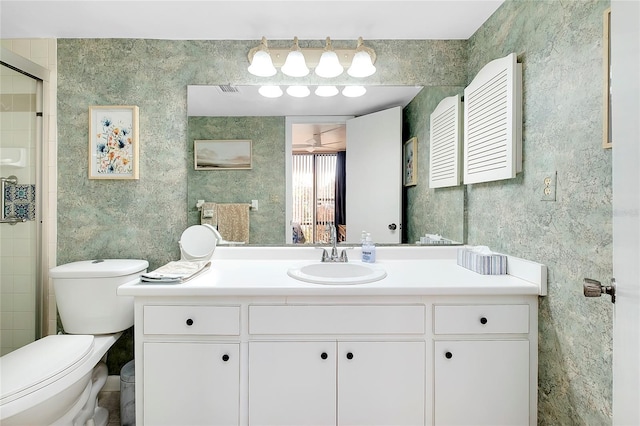 full bath with vanity, toilet, a shower stall, and wallpapered walls