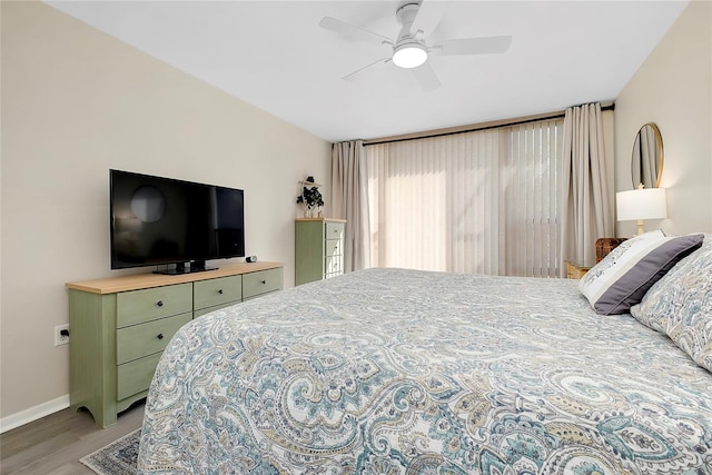 bedroom with ceiling fan, baseboards, and wood finished floors