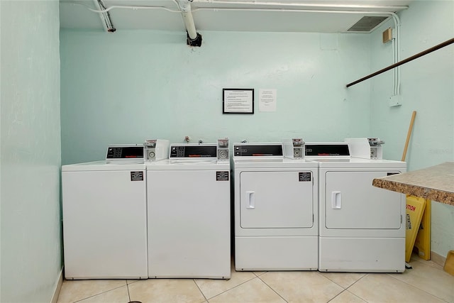 common laundry area with washer and dryer, light tile patterned floors, and visible vents