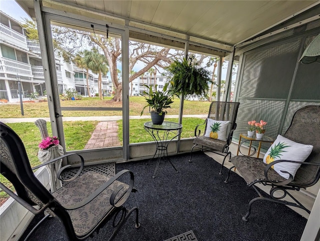 sunroom / solarium featuring wooden ceiling and a residential view