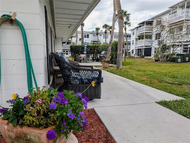 view of home's community featuring a lawn and a patio area