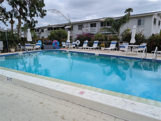 pool with a patio and fence