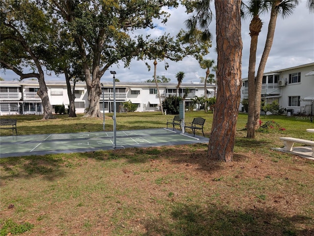 view of community featuring a residential view, a lawn, and shuffleboard