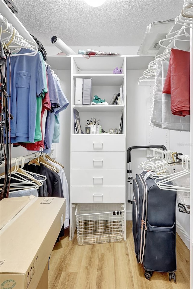 walk in closet with wood finished floors