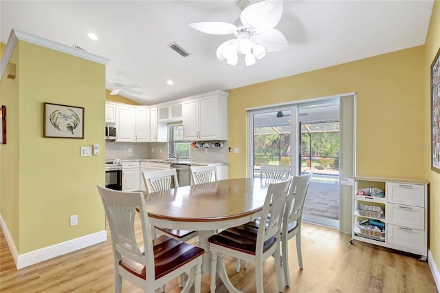 dining space featuring a ceiling fan, light wood-style flooring, lofted ceiling, visible vents, and recessed lighting