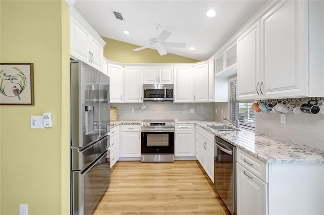 kitchen featuring a ceiling fan, stainless steel appliances, white cabinetry, and a sink