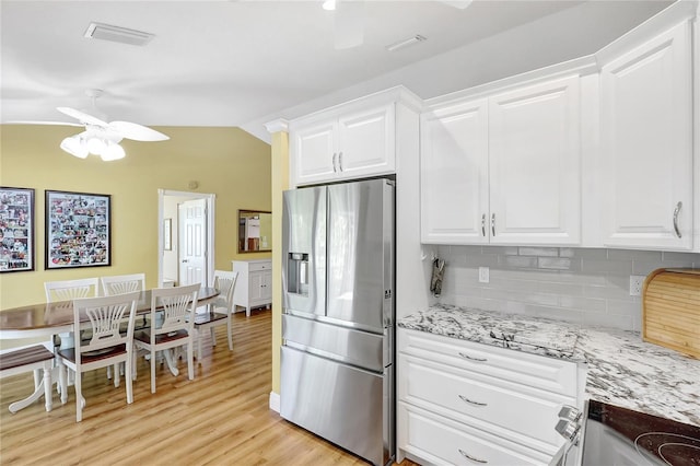 kitchen with ceiling fan, stainless steel fridge with ice dispenser, backsplash, visible vents, and white cabinetry