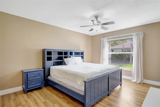 bedroom featuring baseboards, a ceiling fan, and light wood finished floors
