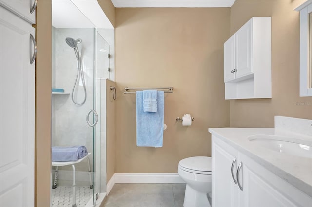 bathroom featuring a shower stall, vanity, baseboards, toilet, and tile patterned flooring