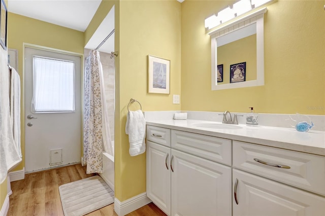 bathroom with shower / tub combo, wood finished floors, and vanity
