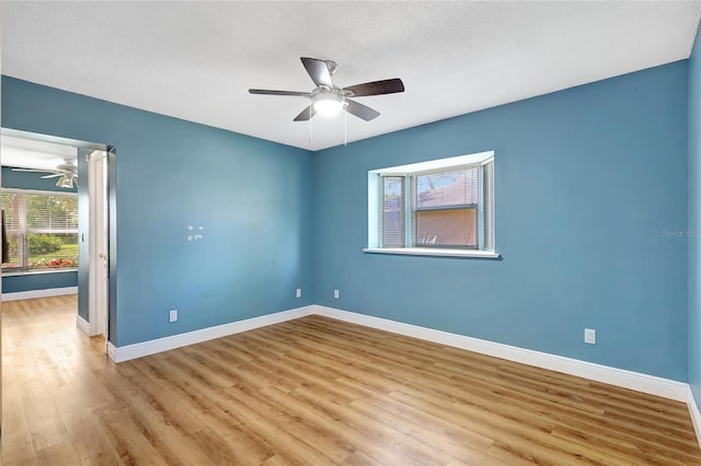 spare room with wood finished floors, baseboards, and ceiling fan