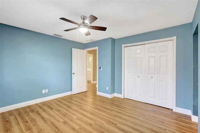 unfurnished bedroom featuring light wood finished floors, baseboards, and a closet