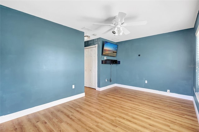 unfurnished room with baseboards, wood finished floors, and ceiling fan