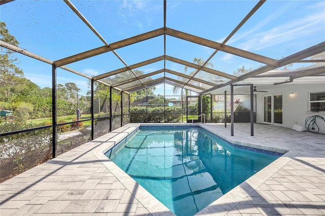 pool featuring glass enclosure, a ceiling fan, and a patio