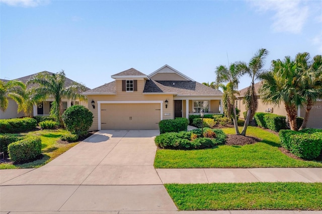 view of front of home featuring driveway, a front yard, and a garage