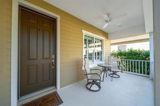 entrance to property featuring a porch and ceiling fan