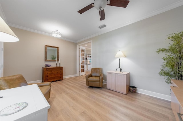 office area with crown molding, a ceiling fan, visible vents, and light wood finished floors