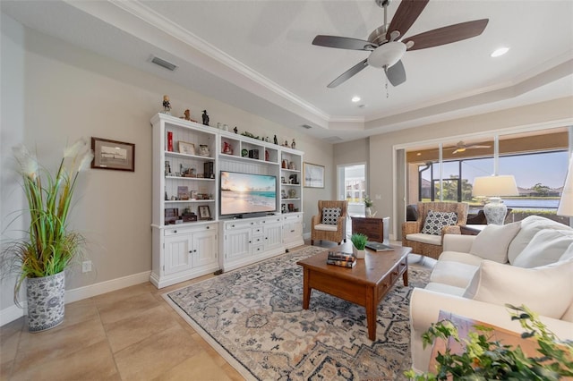 living area with visible vents, a ceiling fan, baseboards, crown molding, and a raised ceiling