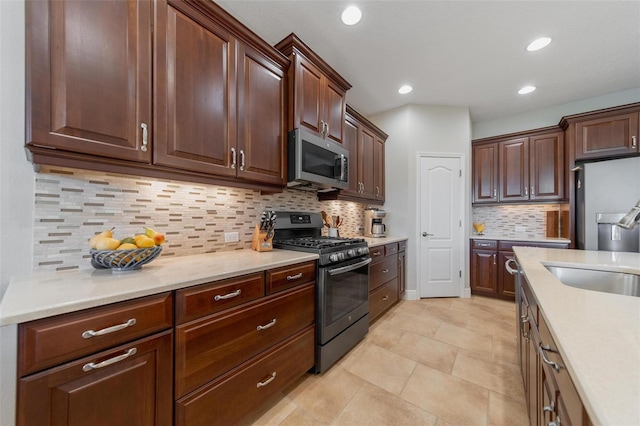 kitchen featuring a sink, tasteful backsplash, recessed lighting, appliances with stainless steel finishes, and light countertops