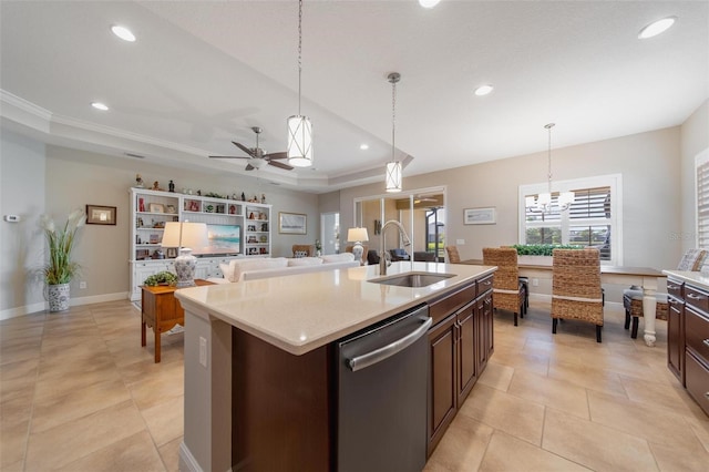 kitchen with ceiling fan with notable chandelier, a sink, stainless steel dishwasher, light countertops, and a raised ceiling