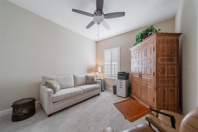 living area featuring light colored carpet, baseboards, and ceiling fan