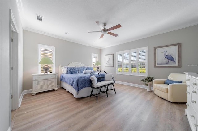 bedroom with visible vents, crown molding, baseboards, light wood-style floors, and a ceiling fan