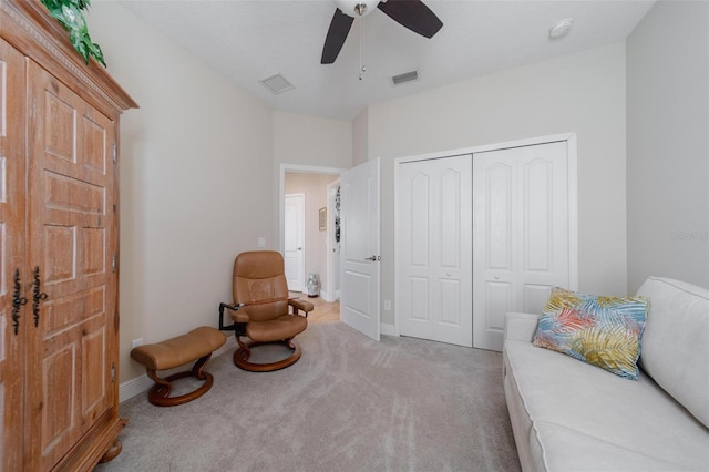 sitting room featuring light carpet, visible vents, baseboards, and ceiling fan