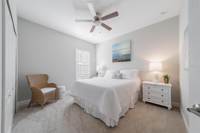 bedroom featuring light carpet, a ceiling fan, and baseboards