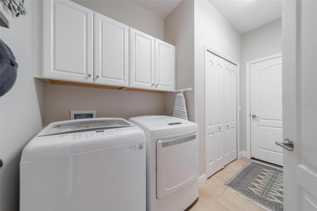 clothes washing area with cabinet space, independent washer and dryer, and light tile patterned flooring