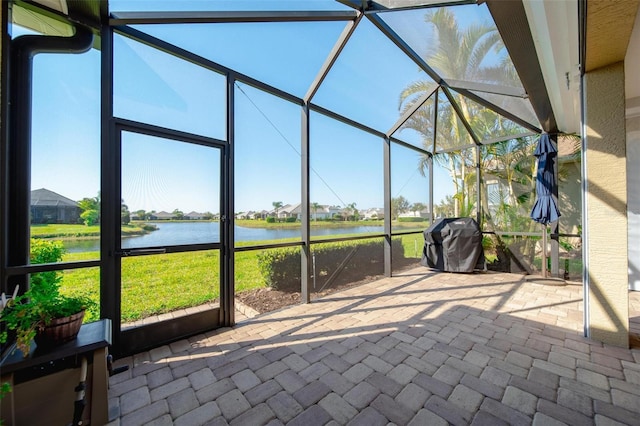 unfurnished sunroom featuring a water view