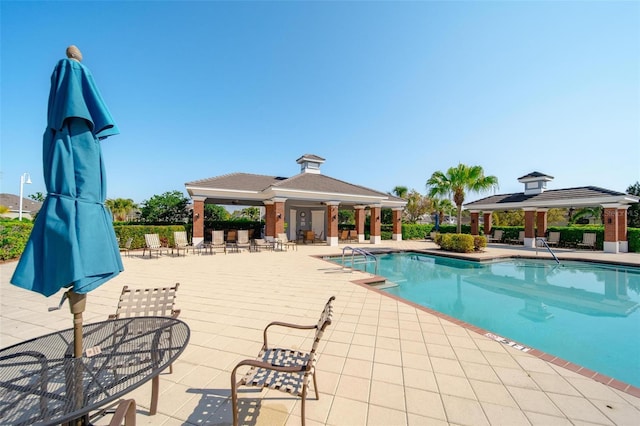 community pool with a gazebo and a patio