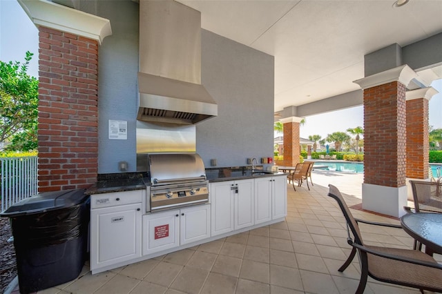 view of patio featuring area for grilling, exterior kitchen, a community pool, and a sink