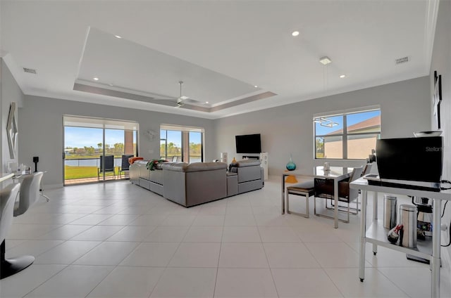 living room featuring a raised ceiling, light tile patterned flooring, and visible vents