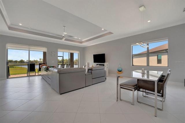 living area featuring ornamental molding, light tile patterned floors, recessed lighting, a raised ceiling, and a ceiling fan