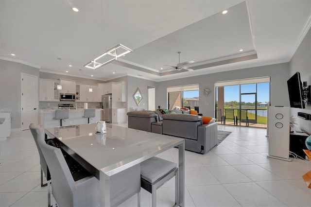 dining area with light tile patterned floors, a raised ceiling, recessed lighting, and crown molding