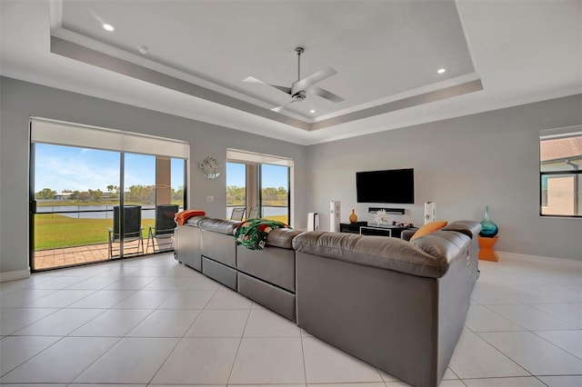 living room featuring ceiling fan, baseboards, a tray ceiling, recessed lighting, and light tile patterned flooring