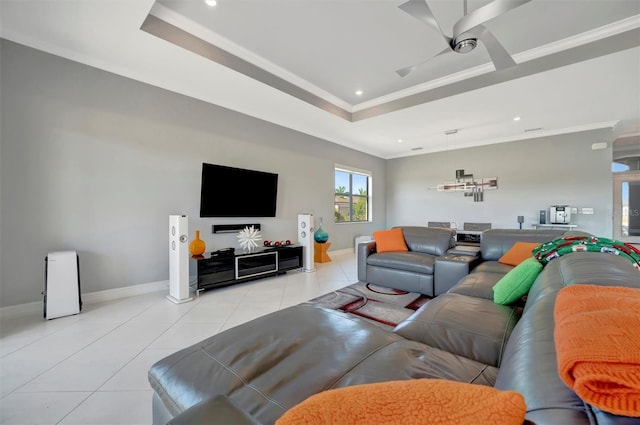 living room with light tile patterned floors, baseboards, a tray ceiling, ceiling fan, and ornamental molding