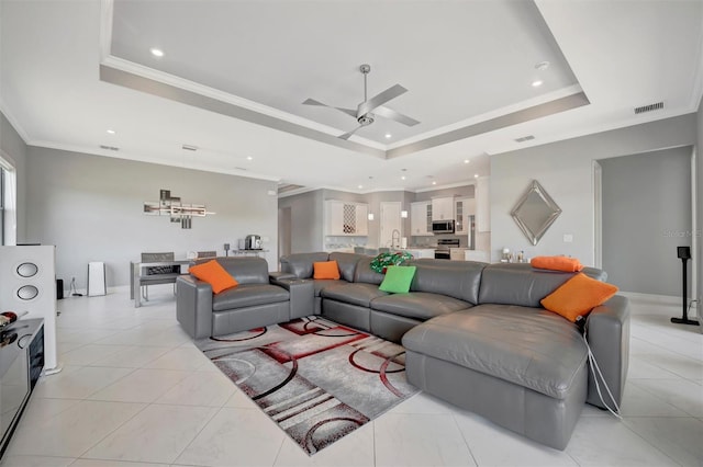 living area featuring visible vents, a raised ceiling, light tile patterned flooring, and crown molding