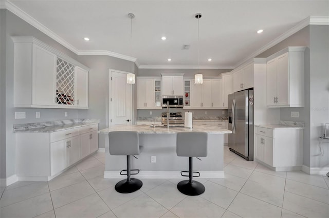 kitchen with a center island with sink, light tile patterned flooring, stainless steel appliances, white cabinets, and crown molding