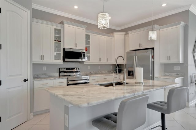 kitchen with a breakfast bar area, light tile patterned floors, a sink, stainless steel appliances, and crown molding