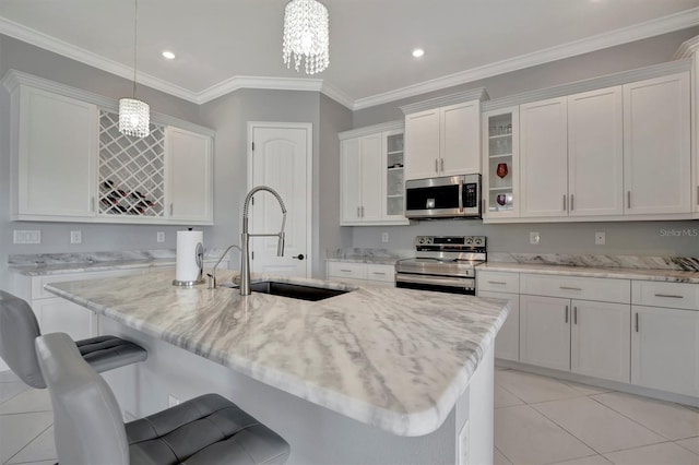 kitchen with a sink, a kitchen breakfast bar, stainless steel appliances, white cabinets, and glass insert cabinets