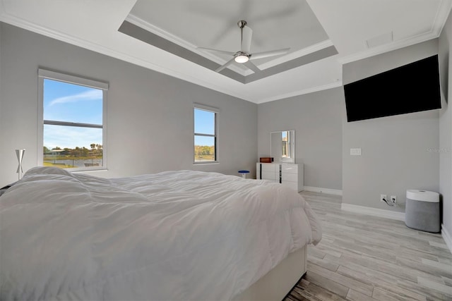 bedroom featuring multiple windows, a raised ceiling, and ornamental molding